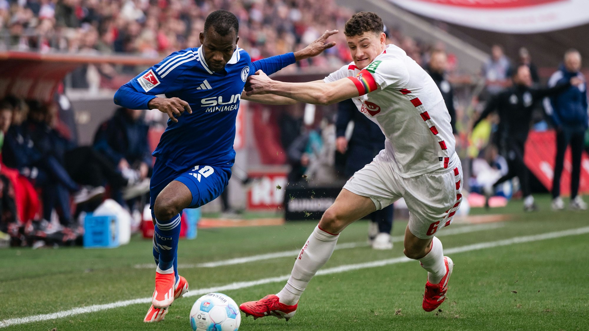 09.02.2025, Nordrhein-Westfalen, Köln: Fußball: 2. Bundesliga, 1. FC Köln - FC Schalke 04, 21. Spieltag, RheinEnergieStadion. Schalkes Pape Meissa Ba (l) und Kölns Eric Martel kämpfen um den Ball. (zu dpa: «Köln muss auf Defensivspieler Eric Martel verzichten») Foto: Marius Becker/dpa +++ dpa-Bildfunk +++