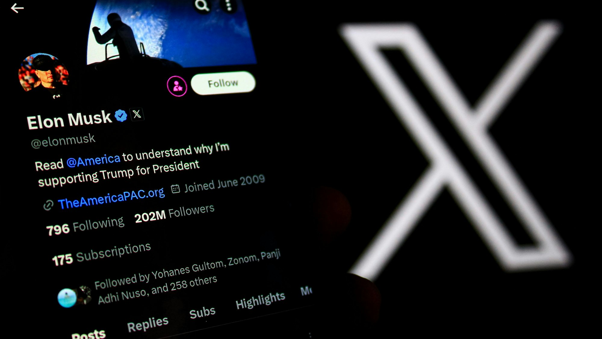 In dieser Fotoillustration wird das X-Kontoprofil von Elon Musk auf einem Smartphone mit einem X-Logo im Hintergrund angezeigt.