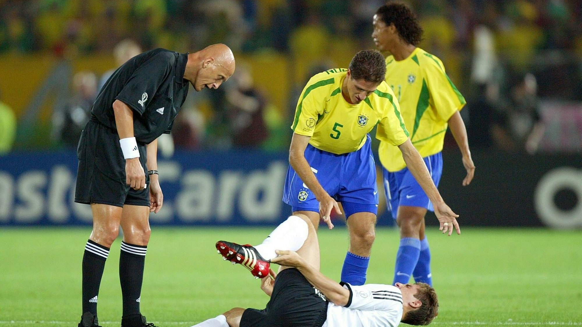 Schiedsrichter Pierluigi Collina und Edmilson fordern von Miroslav Klose Deutschland aufzustehen.