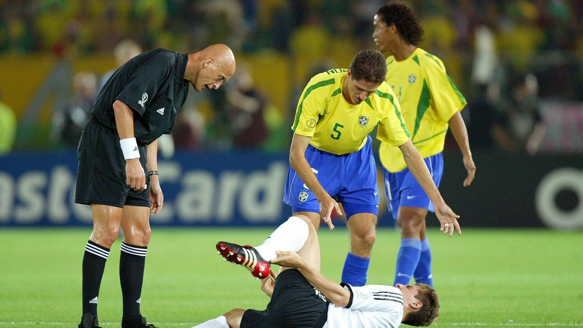 Schiedsrichter Pierluigi Collina und Edmilson fordern von Miroslav Klose Deutschland aufzustehen.