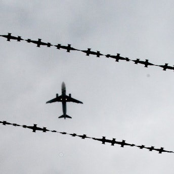 ARCHIV - 22.10.2015, Niedersachsen, Hannover: Ein Flugzeug ist hinter Stacheldraht zu sehen. Nordrhein-Westfalen hat im vergangenen Jahr 3118 Menschen abgeschoben - im Vergleich der Bundesländer sind das die meisten. (zu dpa: «Land NRW führt erstmals eigenen Abschiebeflug durch») Foto: Julian Stratenschulte/dpa +++ dpa-Bildfunk +++