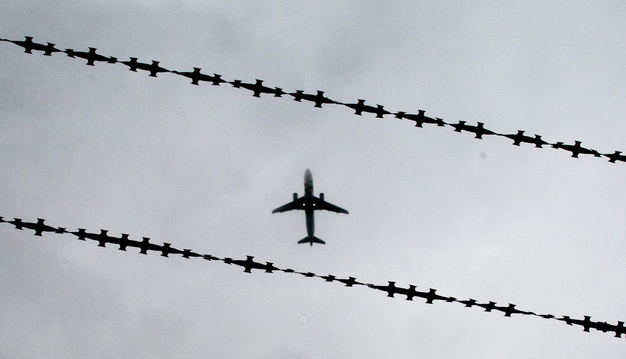 ARCHIV - 22.10.2015, Niedersachsen, Hannover: Ein Flugzeug ist hinter Stacheldraht zu sehen. Nordrhein-Westfalen hat im vergangenen Jahr 3118 Menschen abgeschoben - im Vergleich der Bundesländer sind das die meisten. (zu dpa: «Land NRW führt erstmals eigenen Abschiebeflug durch») Foto: Julian Stratenschulte/dpa +++ dpa-Bildfunk +++