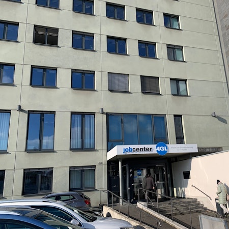 Eine Person geht zum Eingang des Jobcenter Leverkusen.