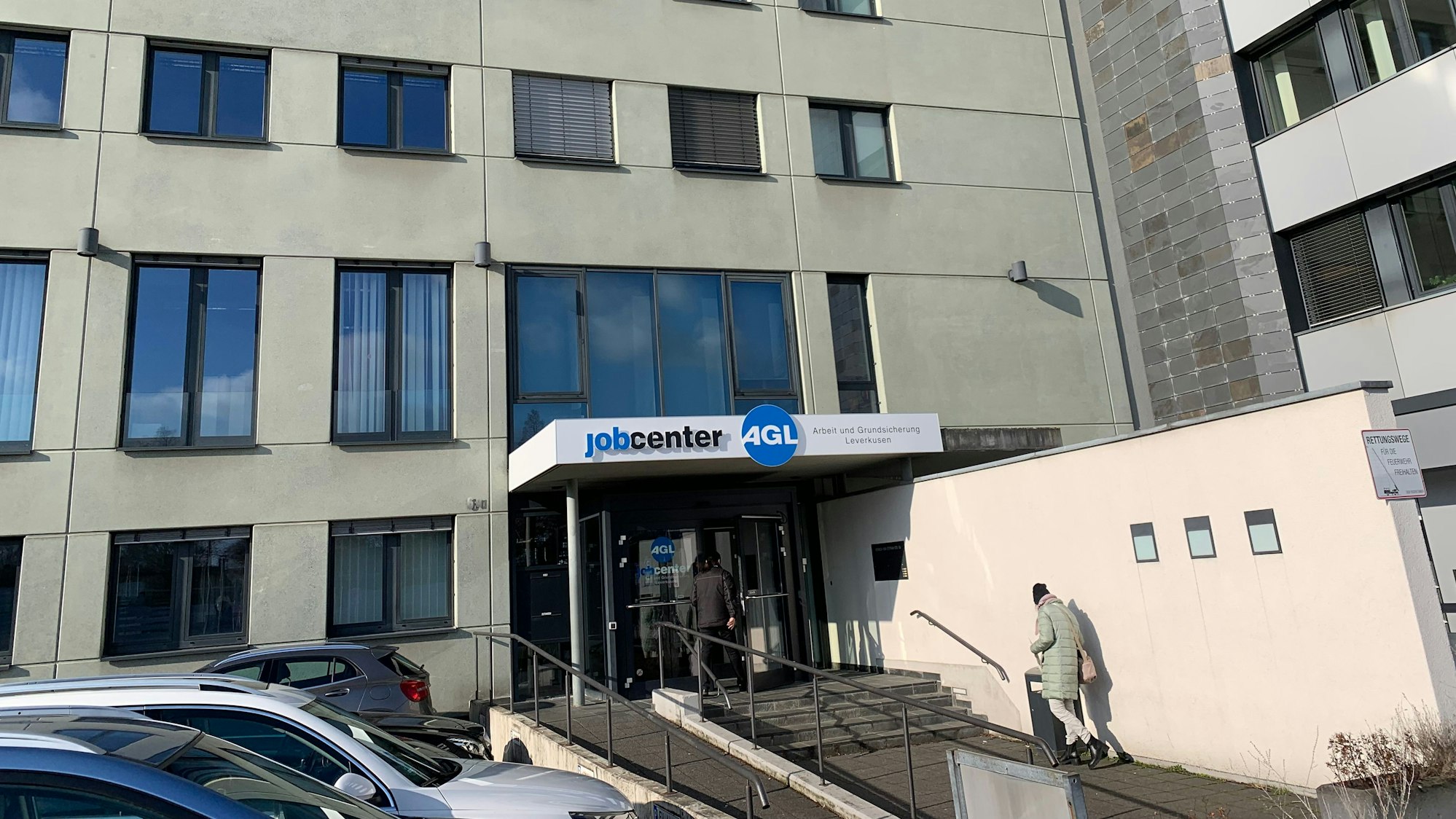 Eine Person geht zum Eingang des Jobcenter Leverkusen.
