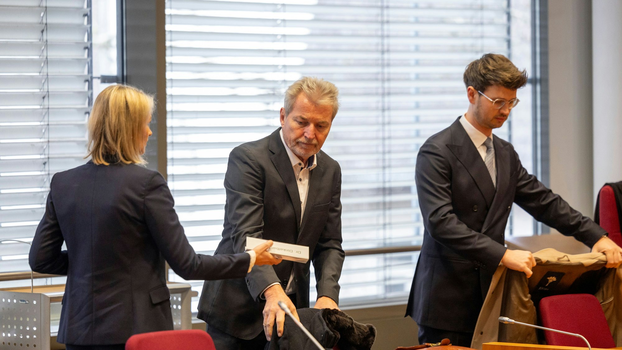 Der angeklagte Kinder- und Jugendpsychiater Michael Winterhoff (M) steht neben seinen Anwälten Kerstin Stirner (l) und Markus Dinkelbach (r) im Gerichtssaal.