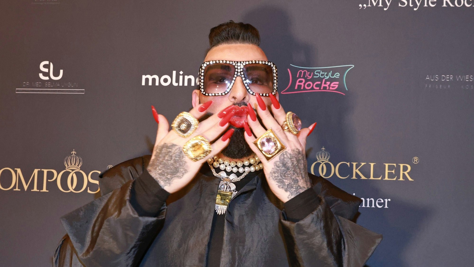 Harald Glööckler wirft den Fotografen Küsse zu.