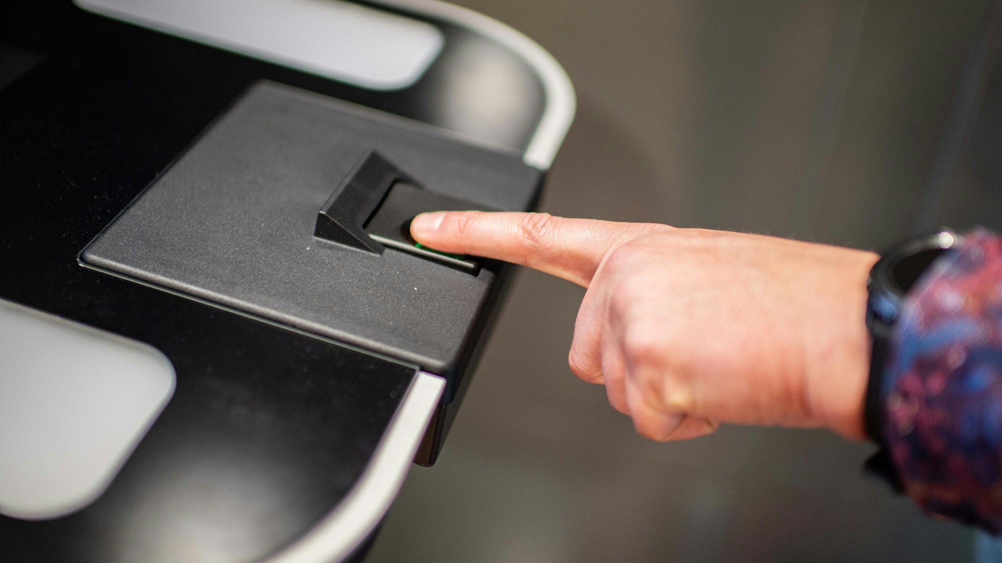 Das Bild zeigt eine Männerhand, die den linken Zeigefinger auf einen Sensor gelegt hat.