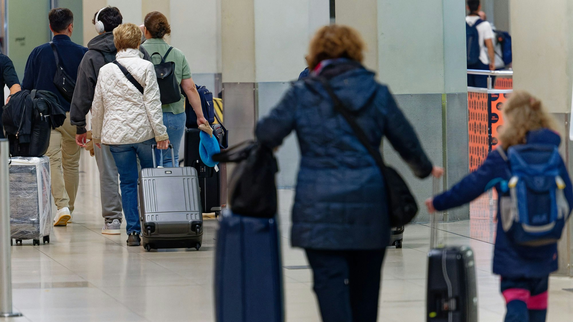 06.07.2024, Nordrhein-Westfalen, Köln: Reisende gehen im Flughafen Köln/Bonn zu ihrem Gate./Bonn. Foto: Henning Kaiser/dpa +++ dpa-Bildfunk +++