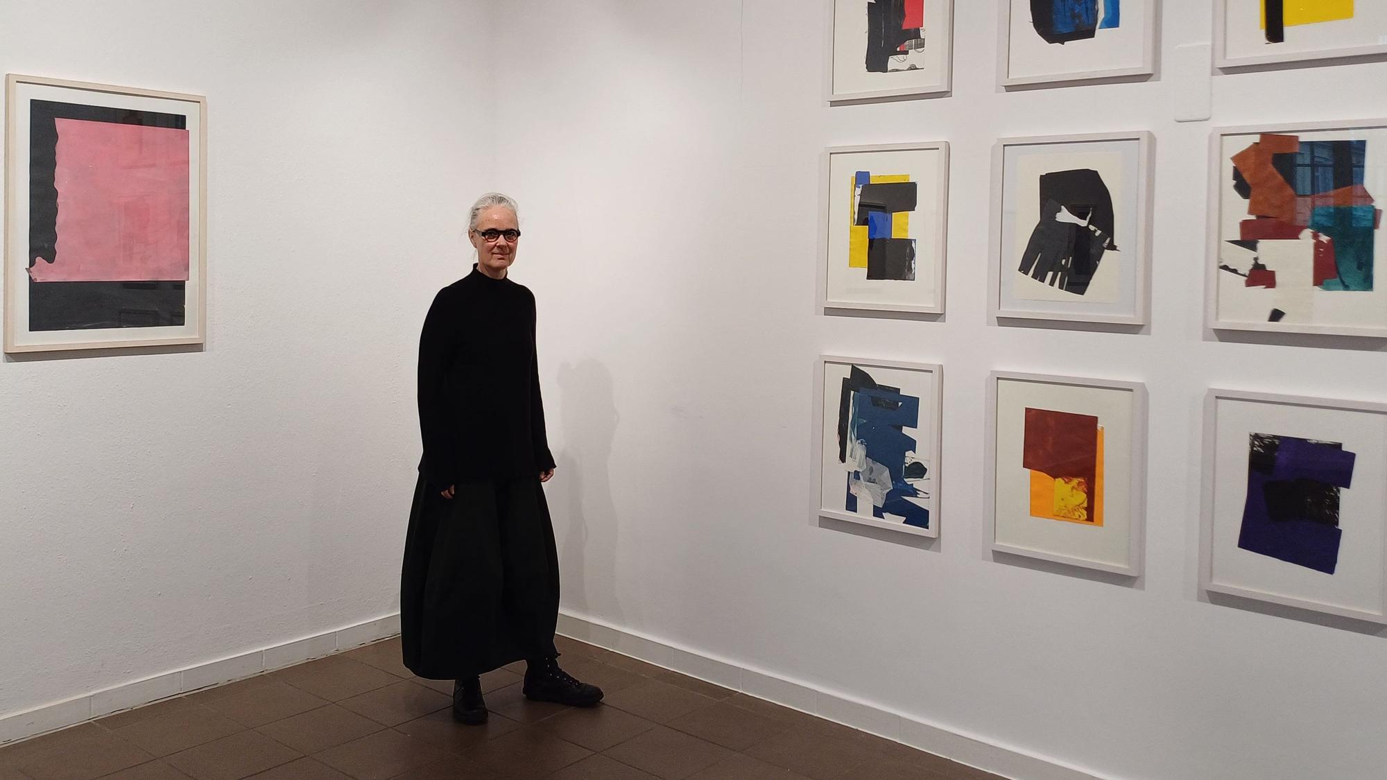Eine Frau steht vor Kunstwerken.