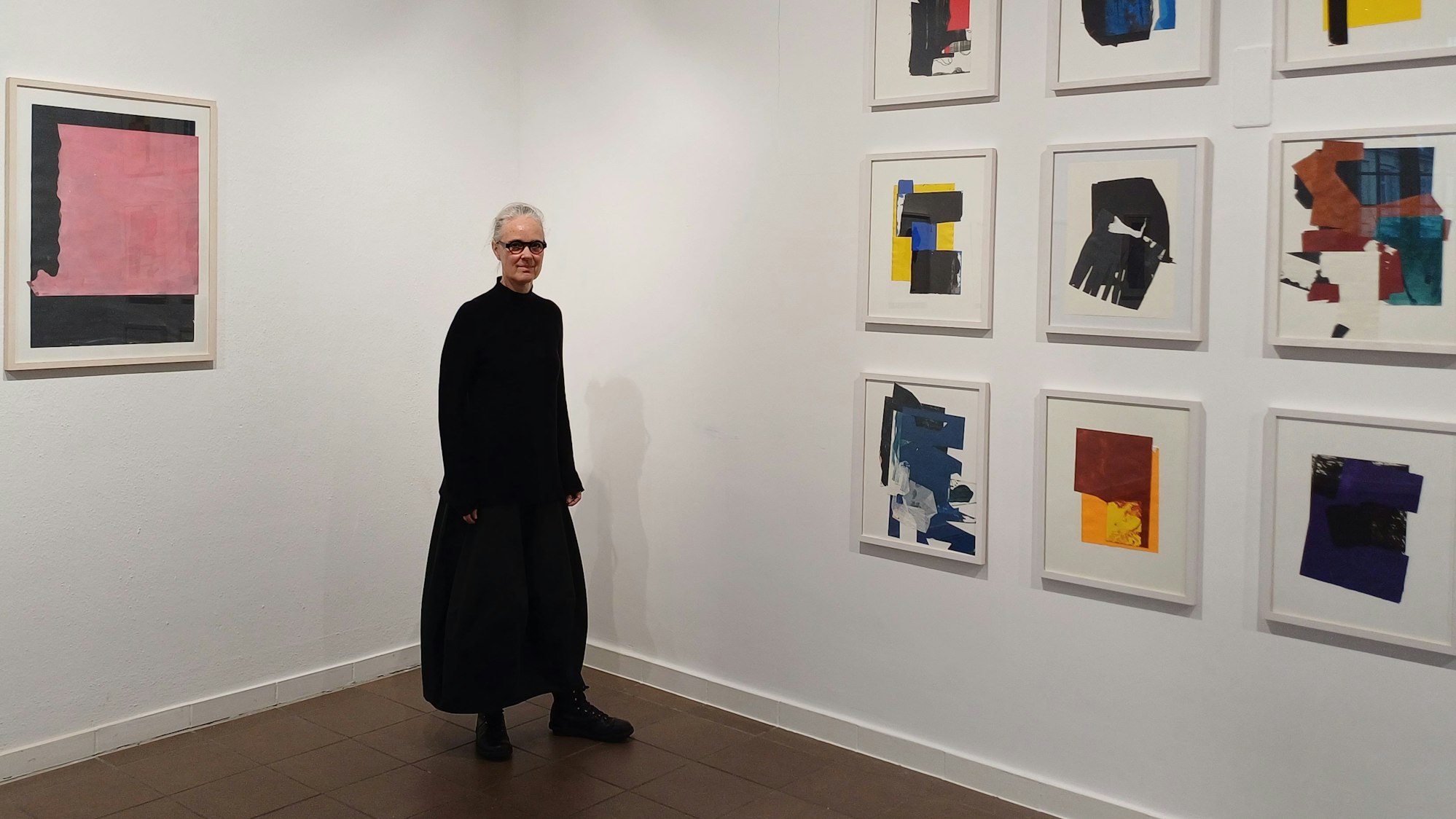 Eine Frau steht vor Kunstwerken.