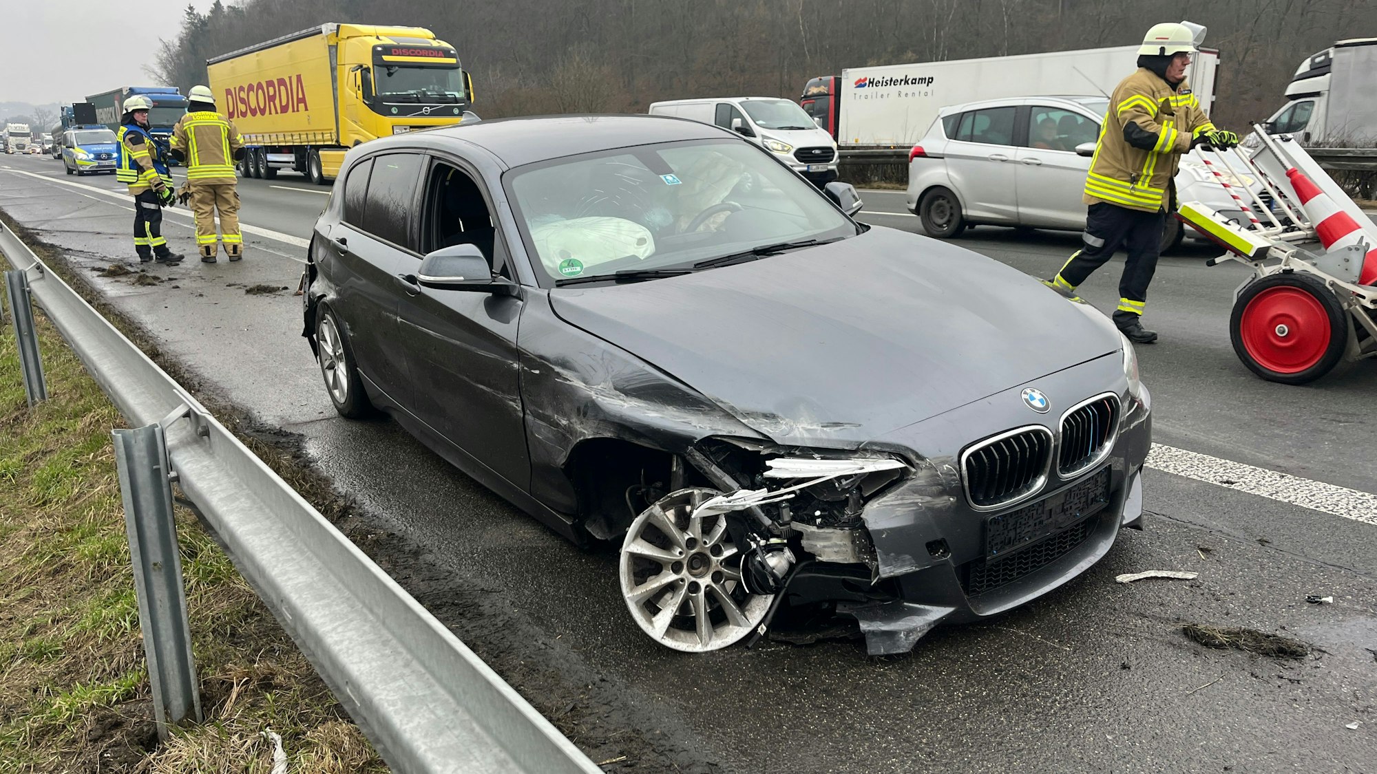 Ein Auto mit abgerissenem Reifen steht an der Leitplanke.