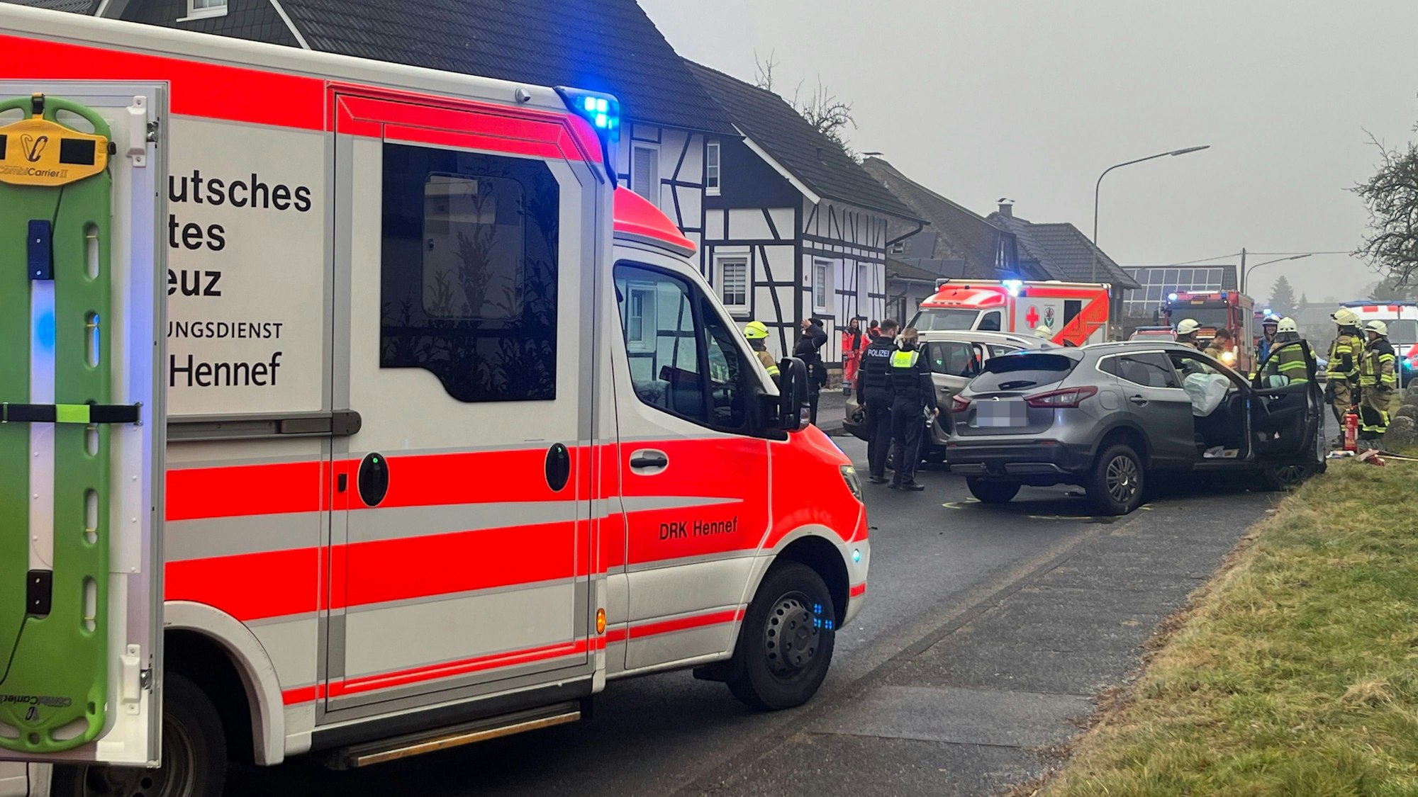 Auf einer Straße sind zwei Autos zusammengestoßen, die Besatzungen von Rettungswagen kümmern sich um die Opfer.