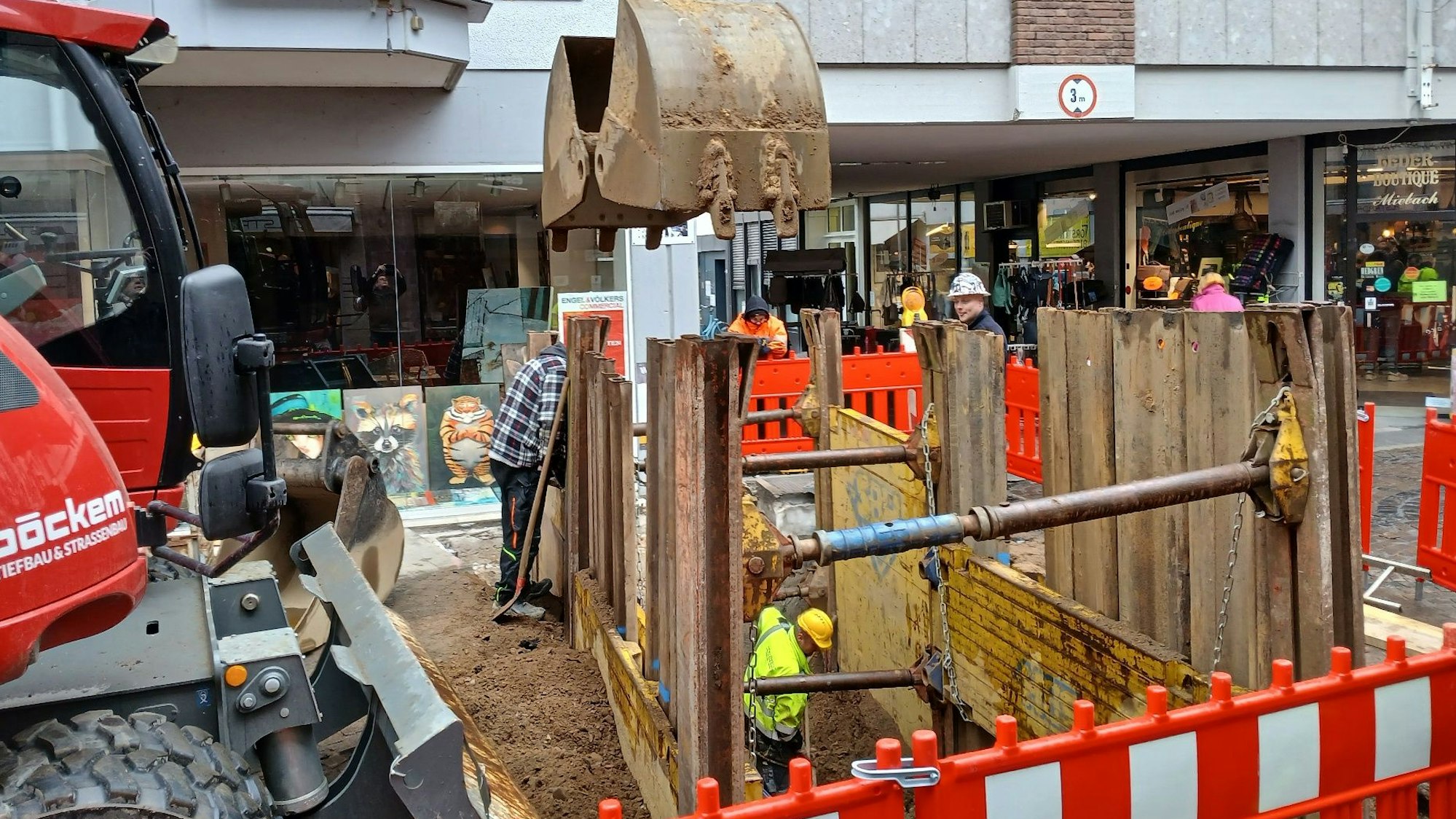 Ein roter Bagger neben einer Baugrube