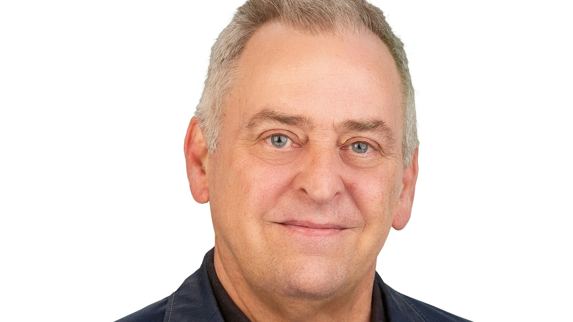 Ein Mann blickt lächelnd zur Kamera.