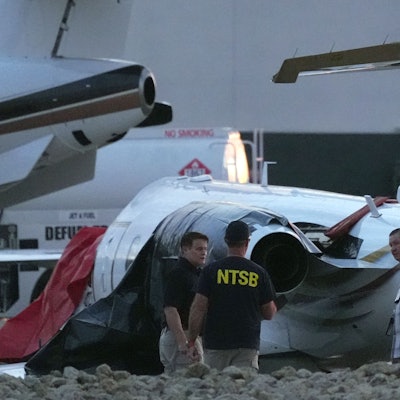 Ermittler untersuchen einen abgestürzten Learjet auf dem Scottsdale Airport, nachdem er in Scottsdale, Arizona, mit einem geparkten Flugzeug kollidiert war.