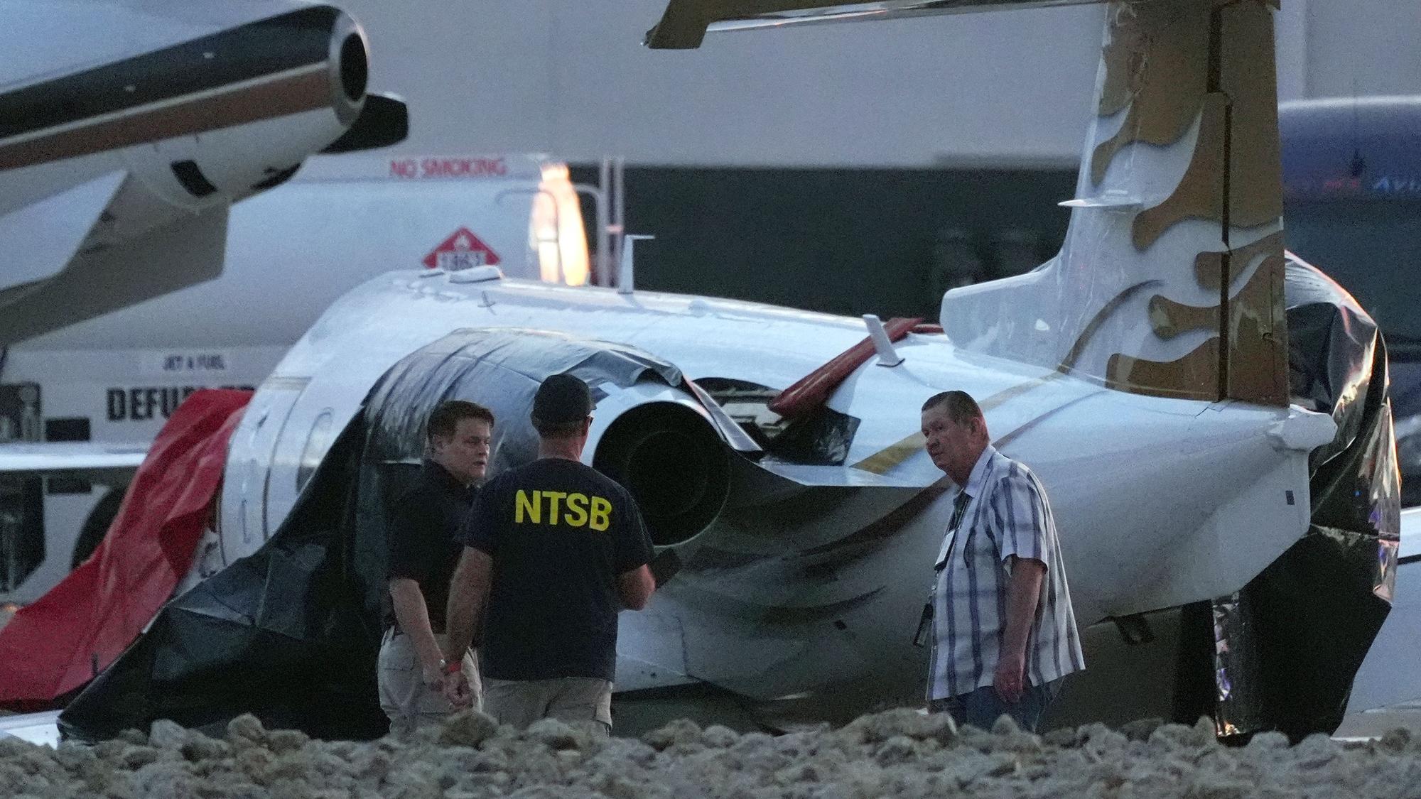 Ermittler untersuchen einen abgestürzten Learjet auf dem Scottsdale Airport, nachdem er in Scottsdale, Arizona, mit einem geparkten Flugzeug kollidiert war.