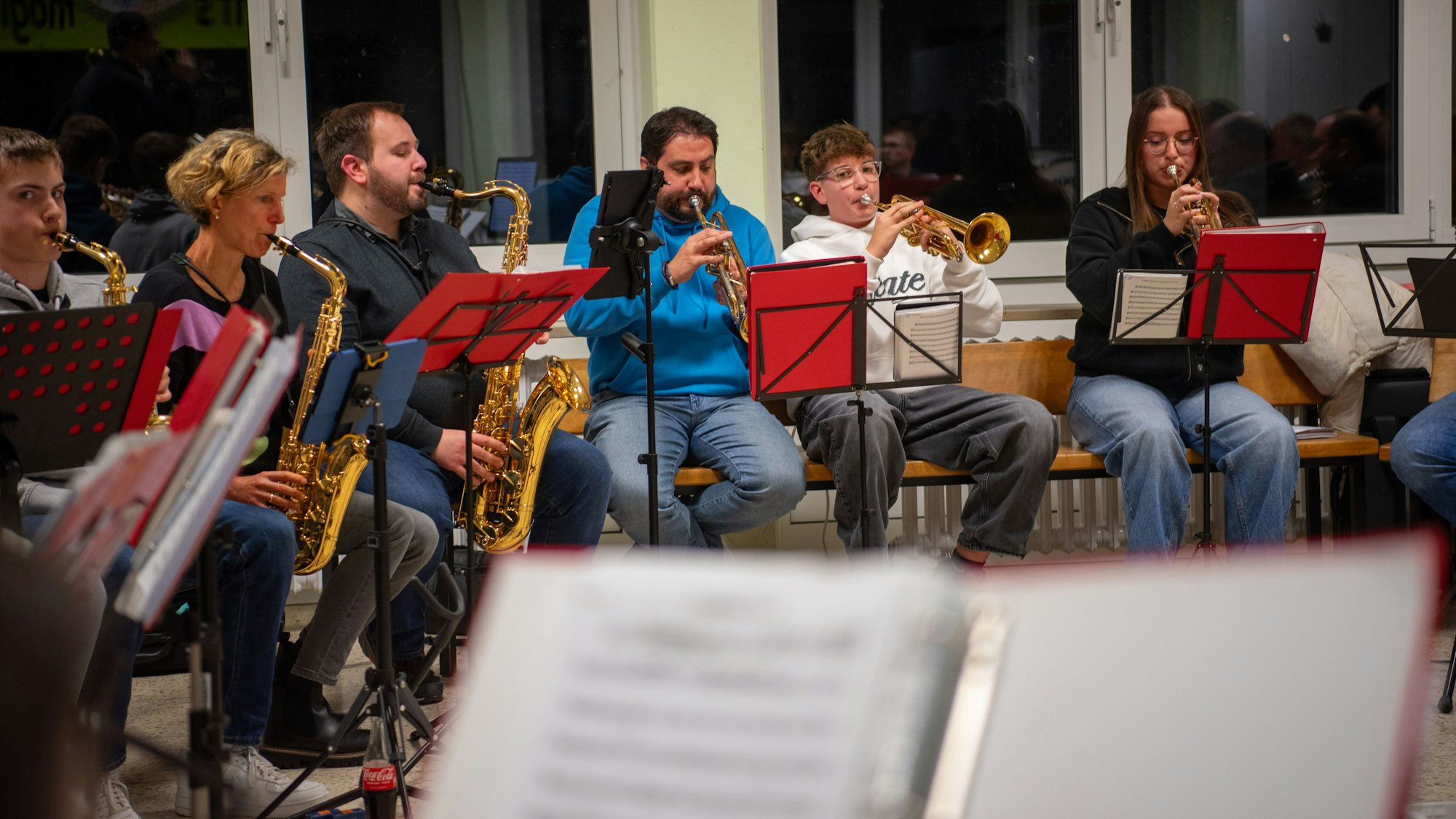 Eine Gruppe von Musikerinnen und Musikern sitzt im Halbkreis und spielt.