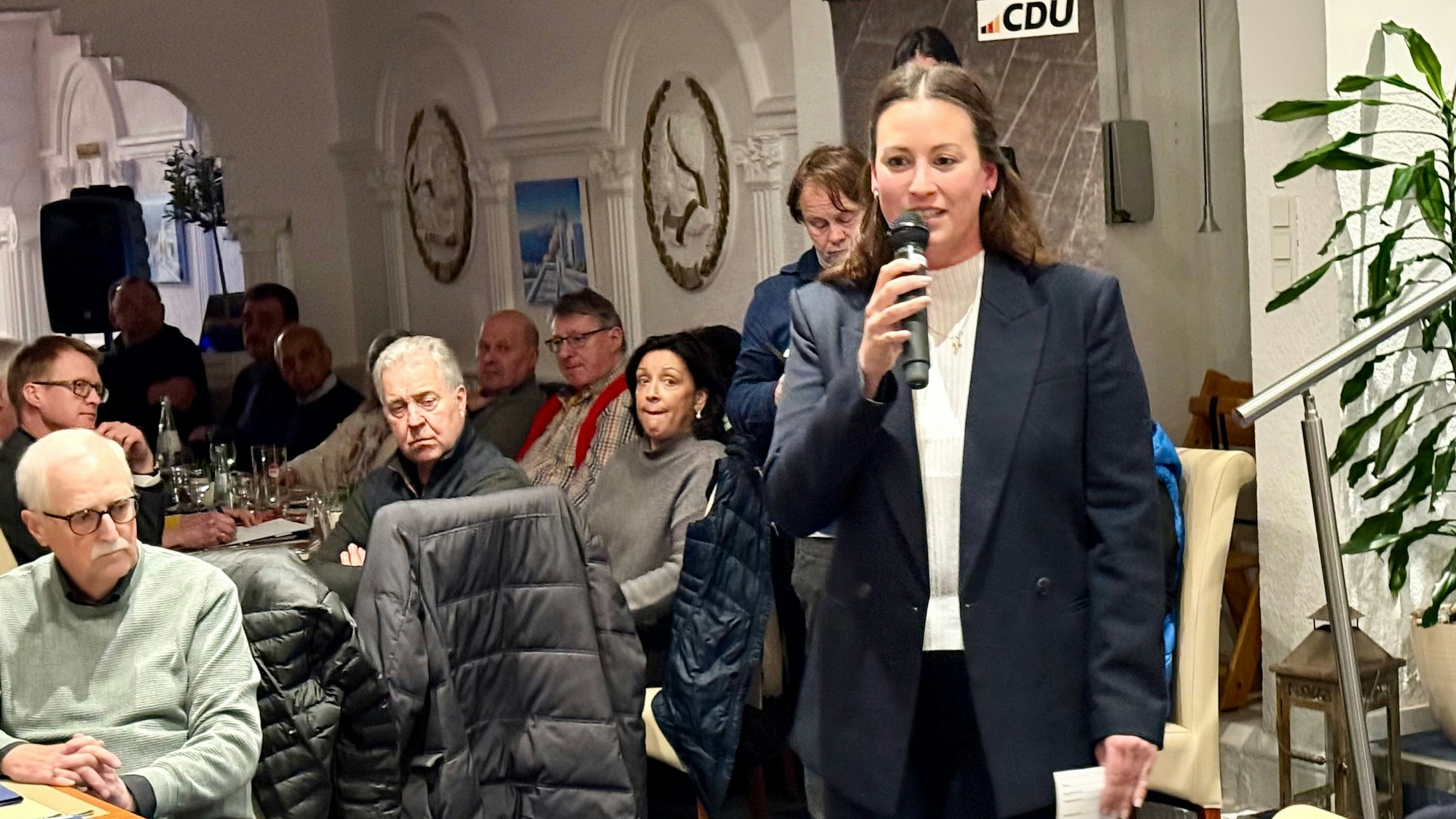 Caroline Bosbach mit Mikrofon im Burscheider Restaurant „Korfu“