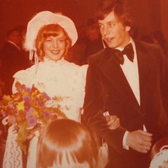 Das Bild hat einen rötlichen Stich. Es zeigt das Paar, festlich gekleidet.