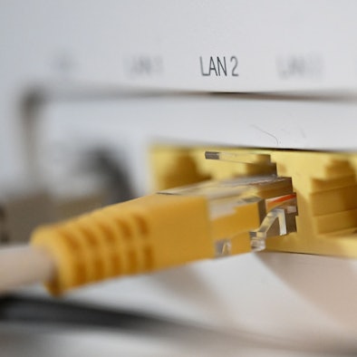 Ein LAN-Kabel steckt in einem Router.
