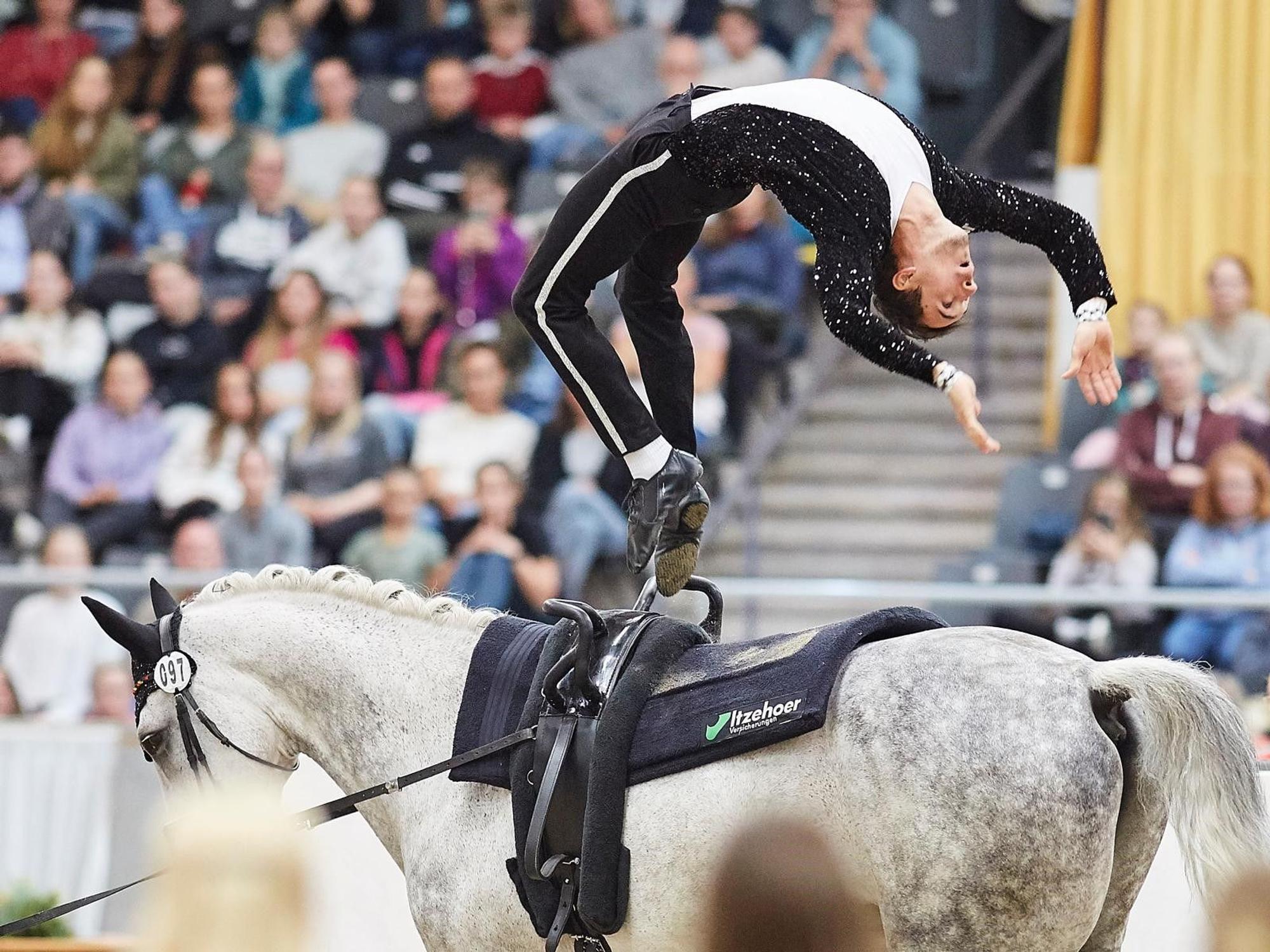 Thomas Brüsewitz turnt einen Flickflack auf dem Pferd William. Er trägt ein Michael-Jackson-Outfit.