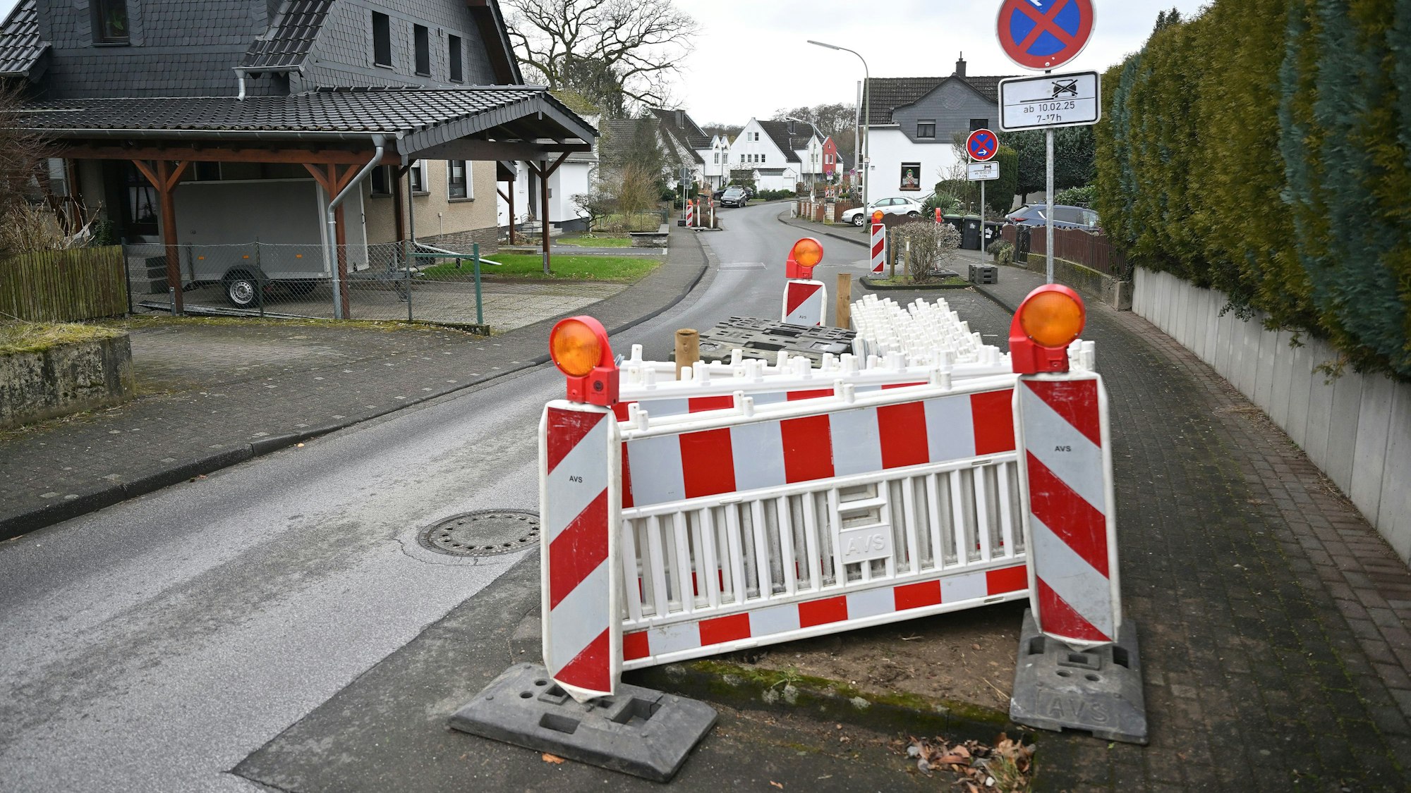 Rot-weiße Warnbaken stehen auf einer Straße.