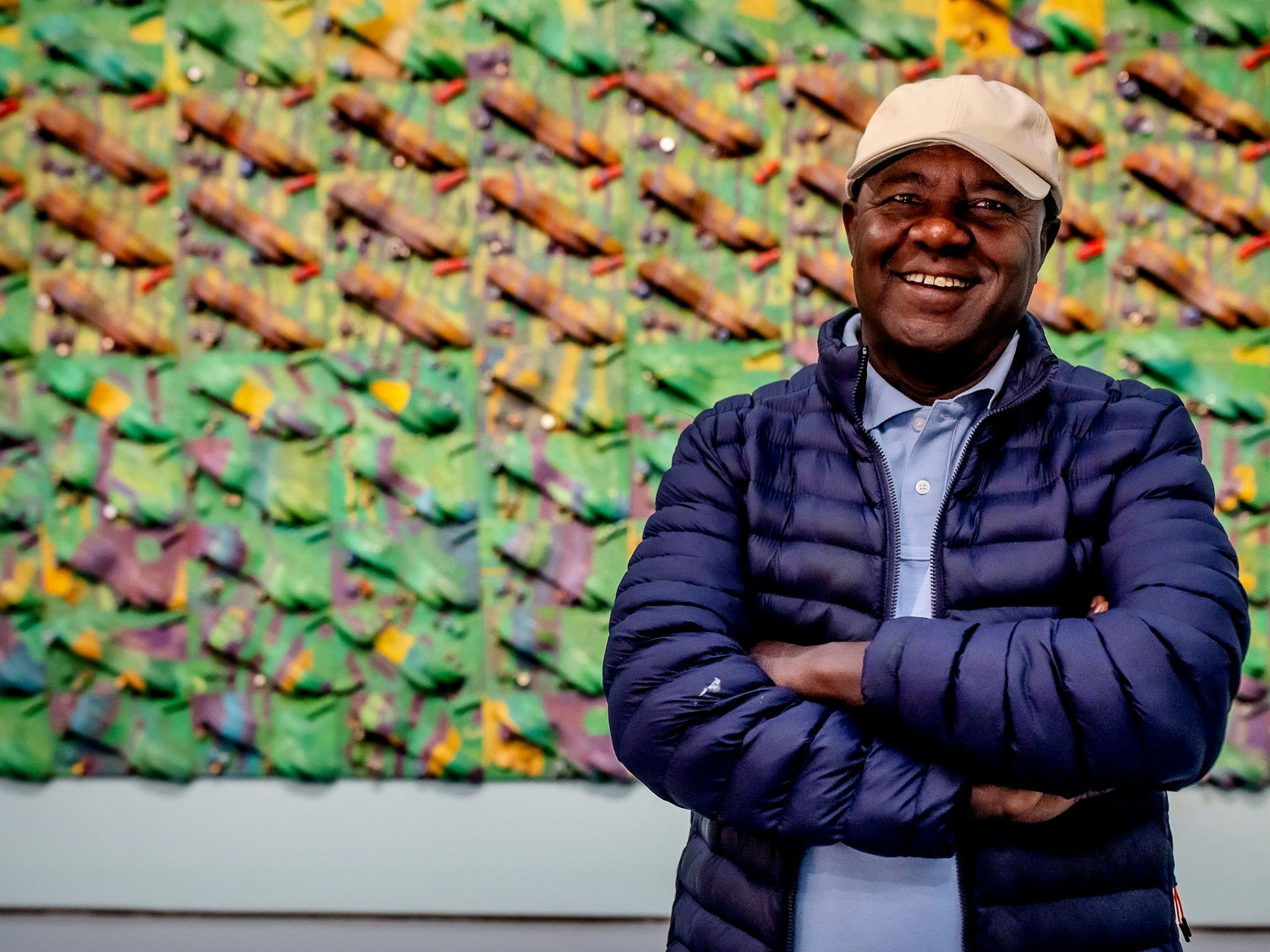 Elias Sime steht vor einem seiner Bilder.