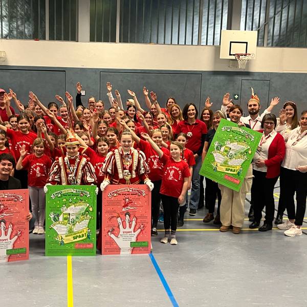 Karnevalisten zeigen Plakate und rufen „Alaaf“ aus.
