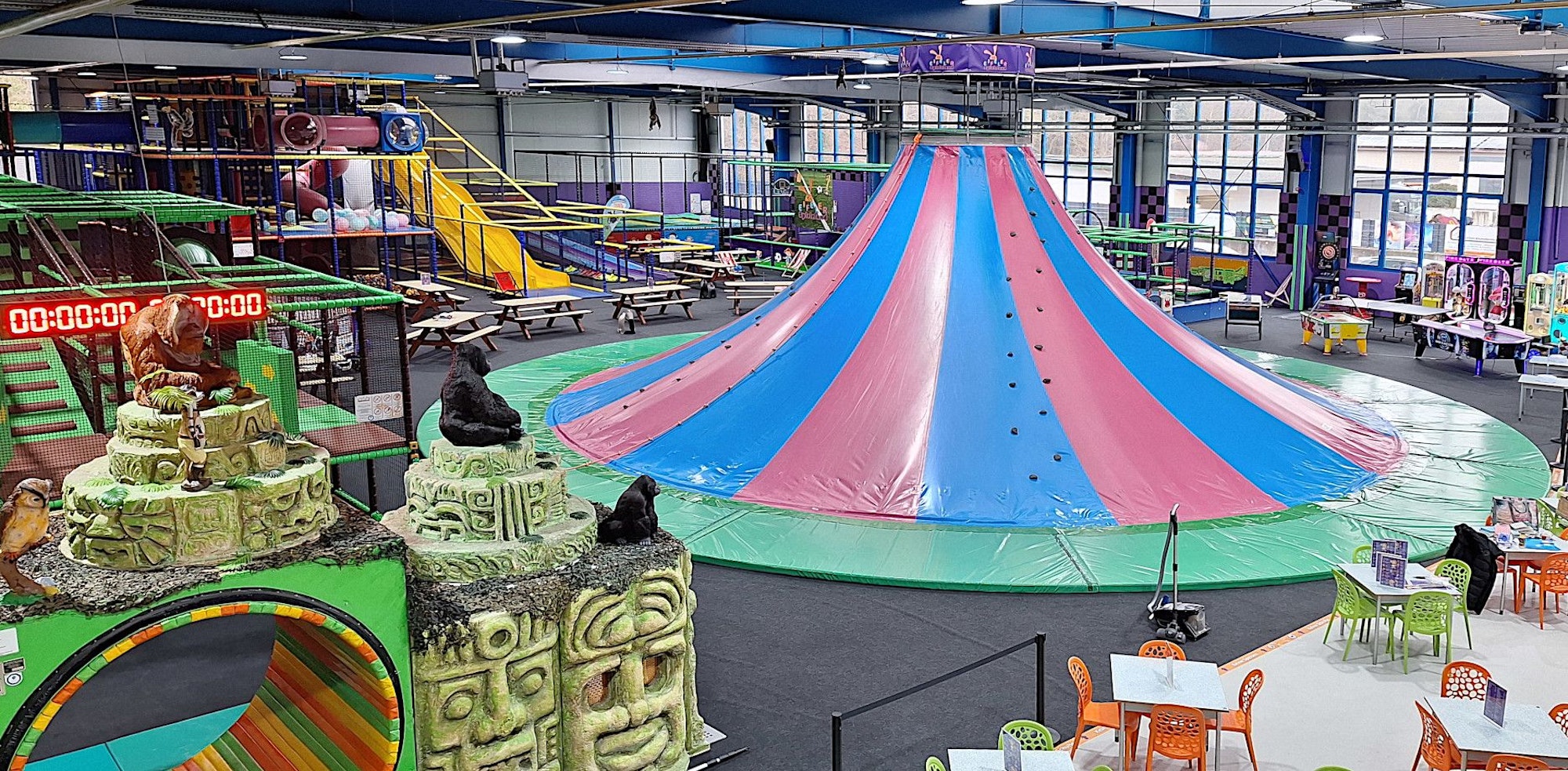 Einem Vulkan ähnelt die rot und blau gestreifte Konstruktion, die in einer Halle des Spielelands in Bad Münstereifel steht und Gelegenheit zum Klettern und Rutschen bietet.