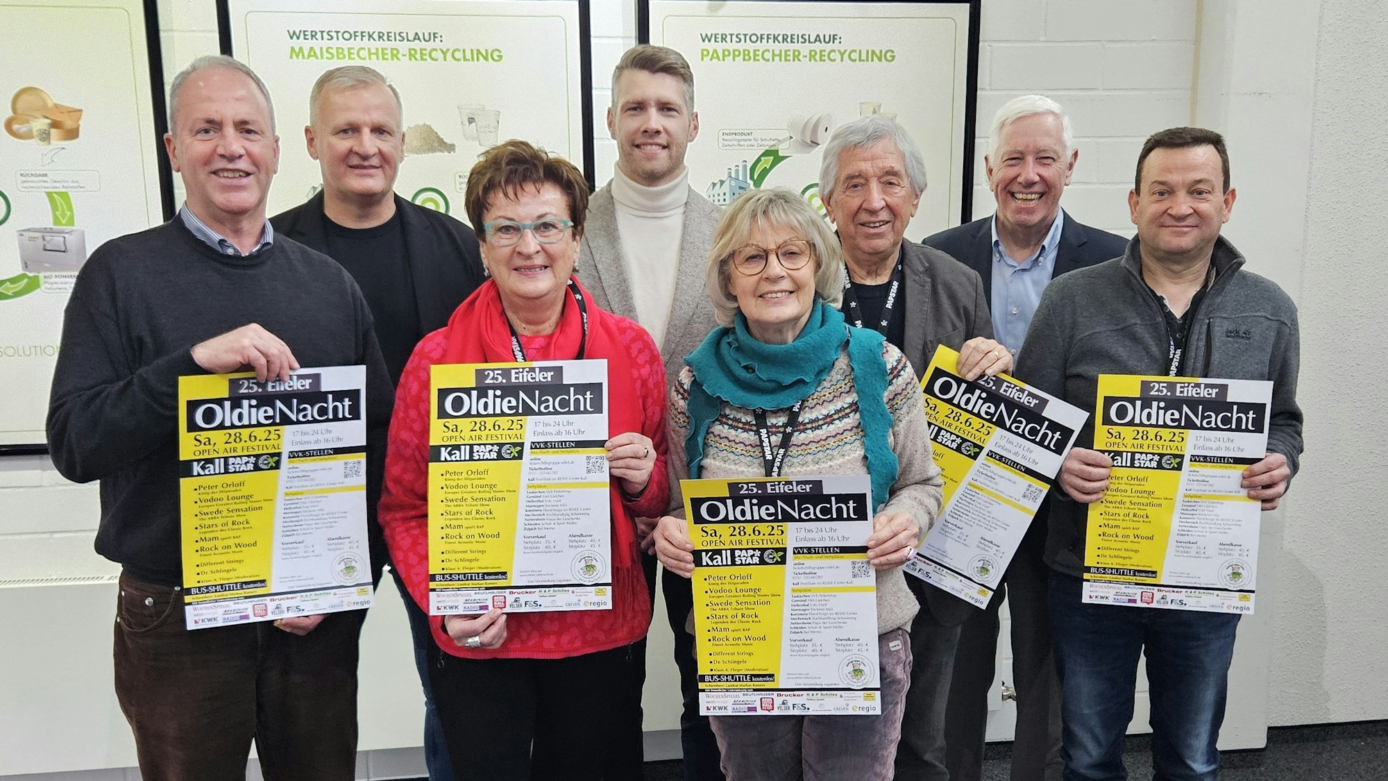 Hermann-Josef Esser, Bernd Born, Dagmar Poth (Hilfsgruppe), Tom Kantelberg; Kathi und Willi Greuel, Bert Kantelberg und Thomas Tampier stehen nebeneinander und präsentieren Plakate von der Oldie-Nacht.