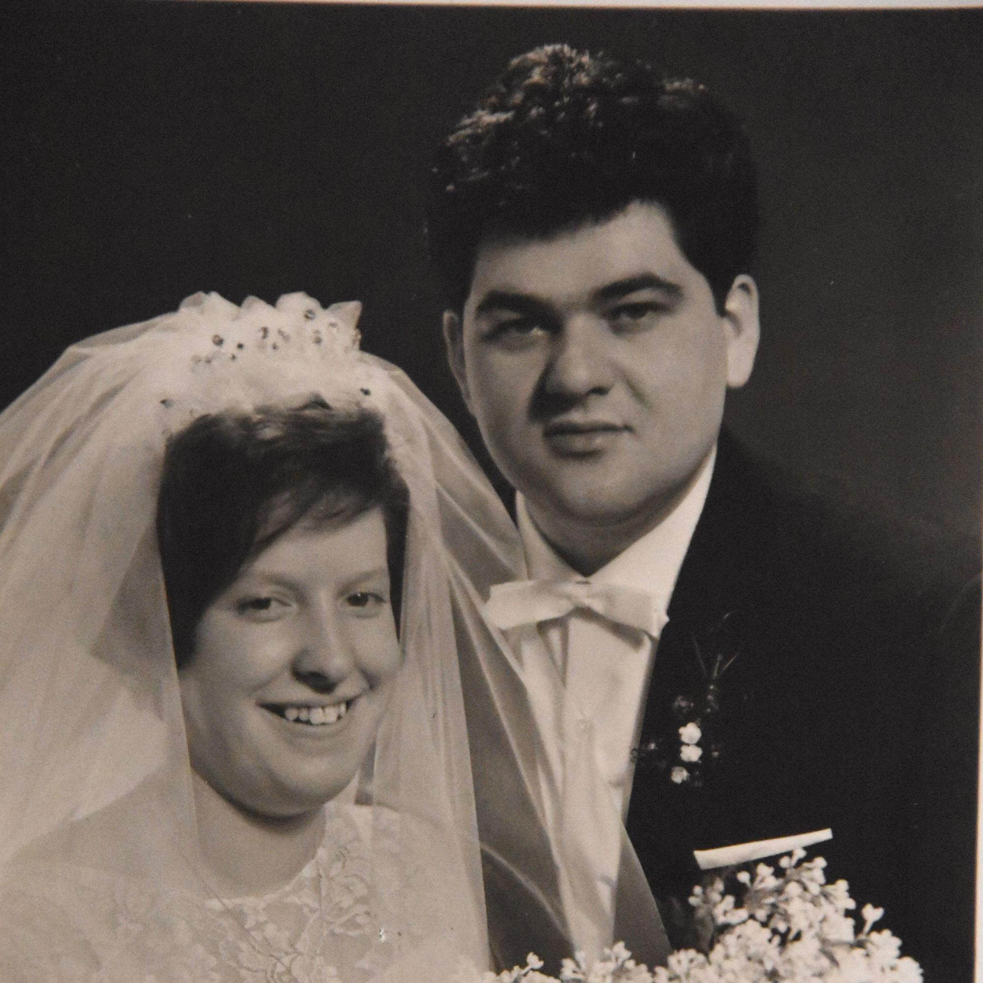 Eine Ehepaar bei seiner Hochzeit in schwarz-weiß.