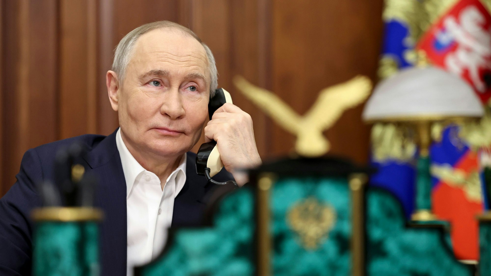 Der russische Präsident Wladimir Putin telefoniert im Kreml mit einem Festnetz-Telefon.