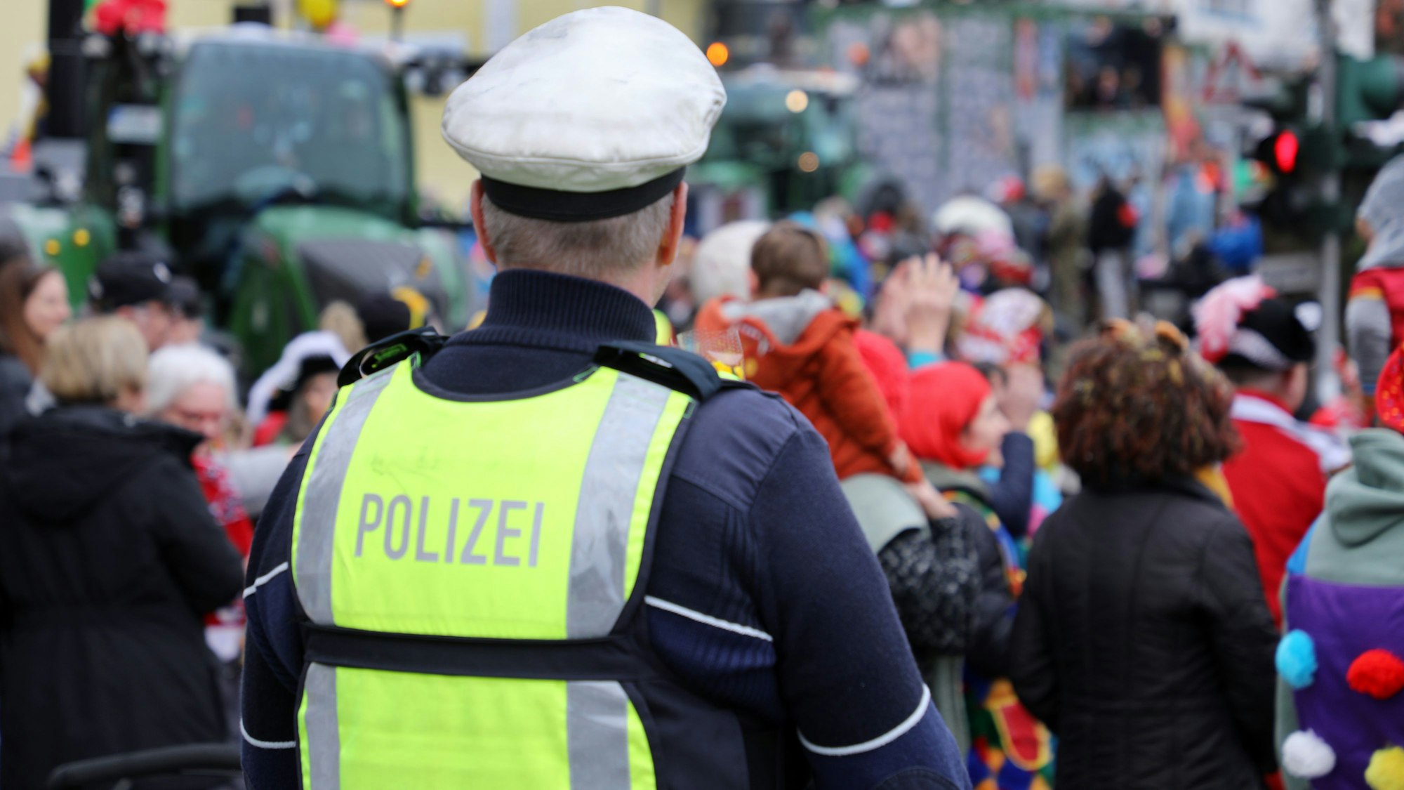 Ein Polizist steht am Rande eines Karnevalszugs in Kürten. (Symbolfoto)