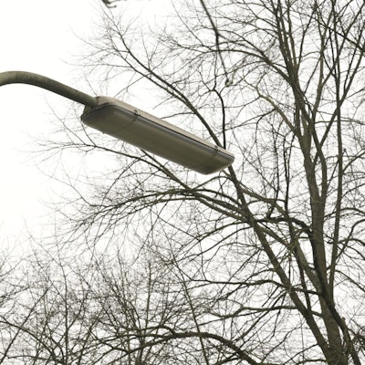 An einer Straße steht eine Straßenlampe in Bogenform.