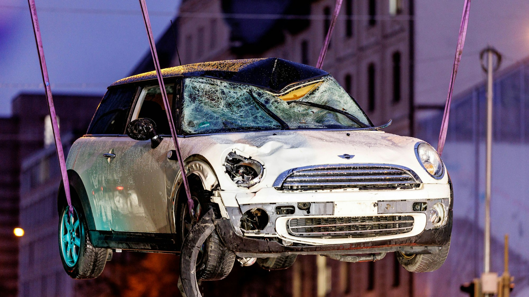 Ein zerstörtes Auto wird am Einsatzort auf einen Abschleppwagen gehoben.