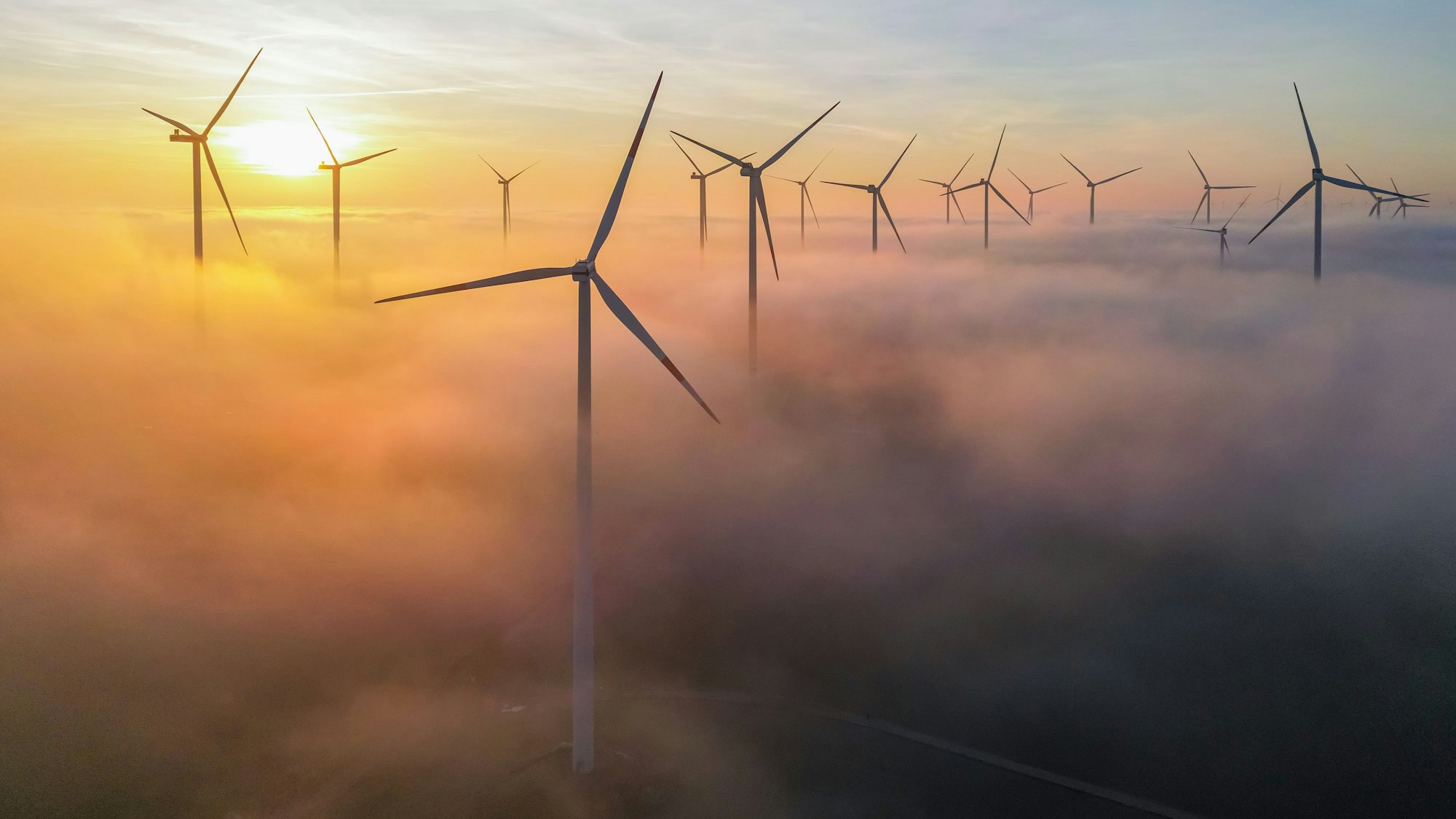 Die Morgensonne leuchtet über dem Nebel zwischen Windenergieanlagen im östlichen Brandenburg (Luftaufnahme mit einer Drohne). (Archivbild)