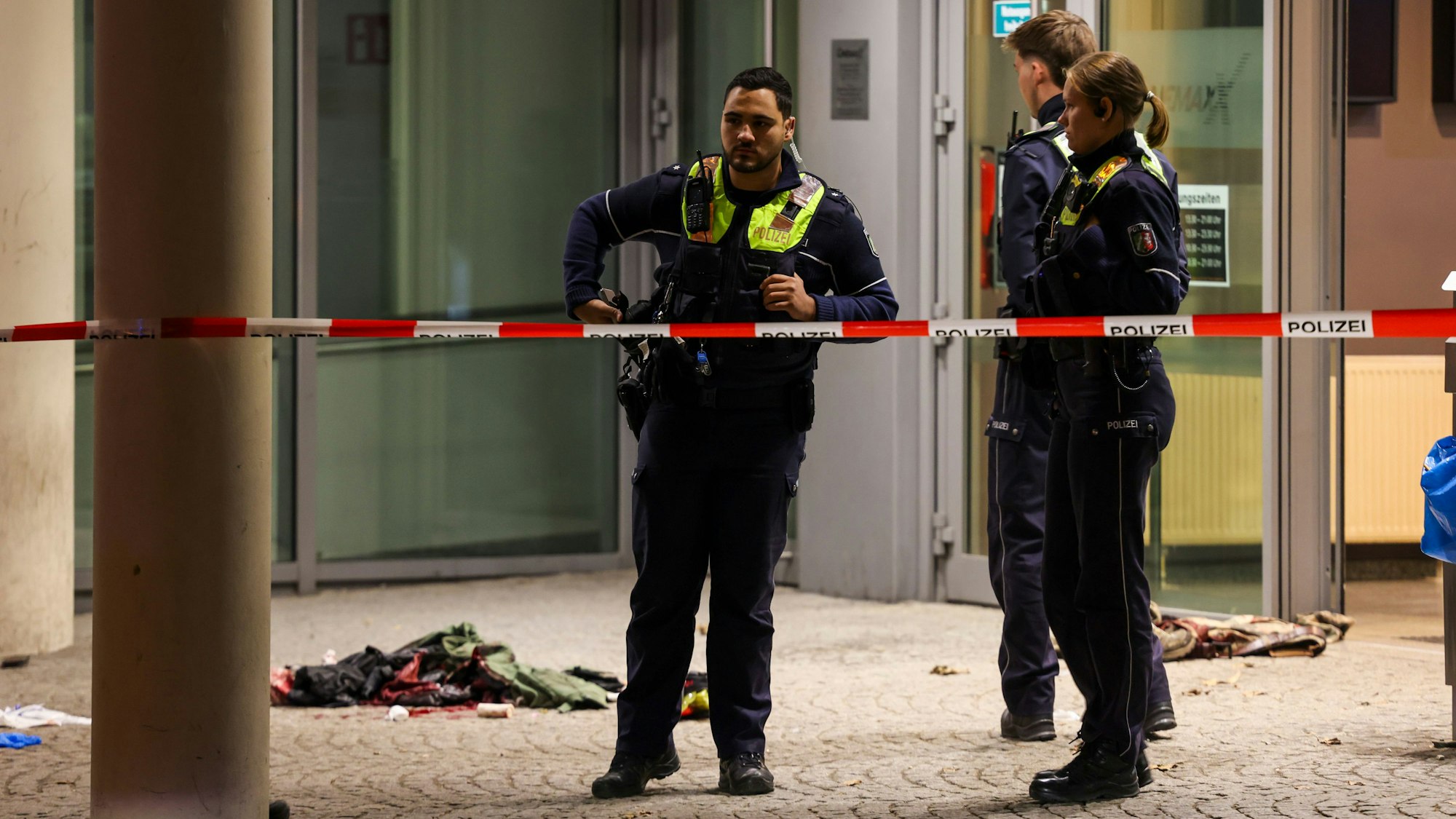 Polizisten sind vor einem Kino in Krefeld im Einsatz, auf dem Boden liegt blutige Kleidung.