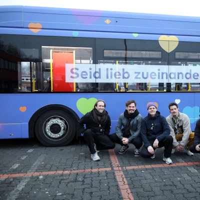Die Band stellt einen Bus vor, der im Rahmen der gemeinsamen Initiative „Seid lieb zueinander“ gestaltet wurde.