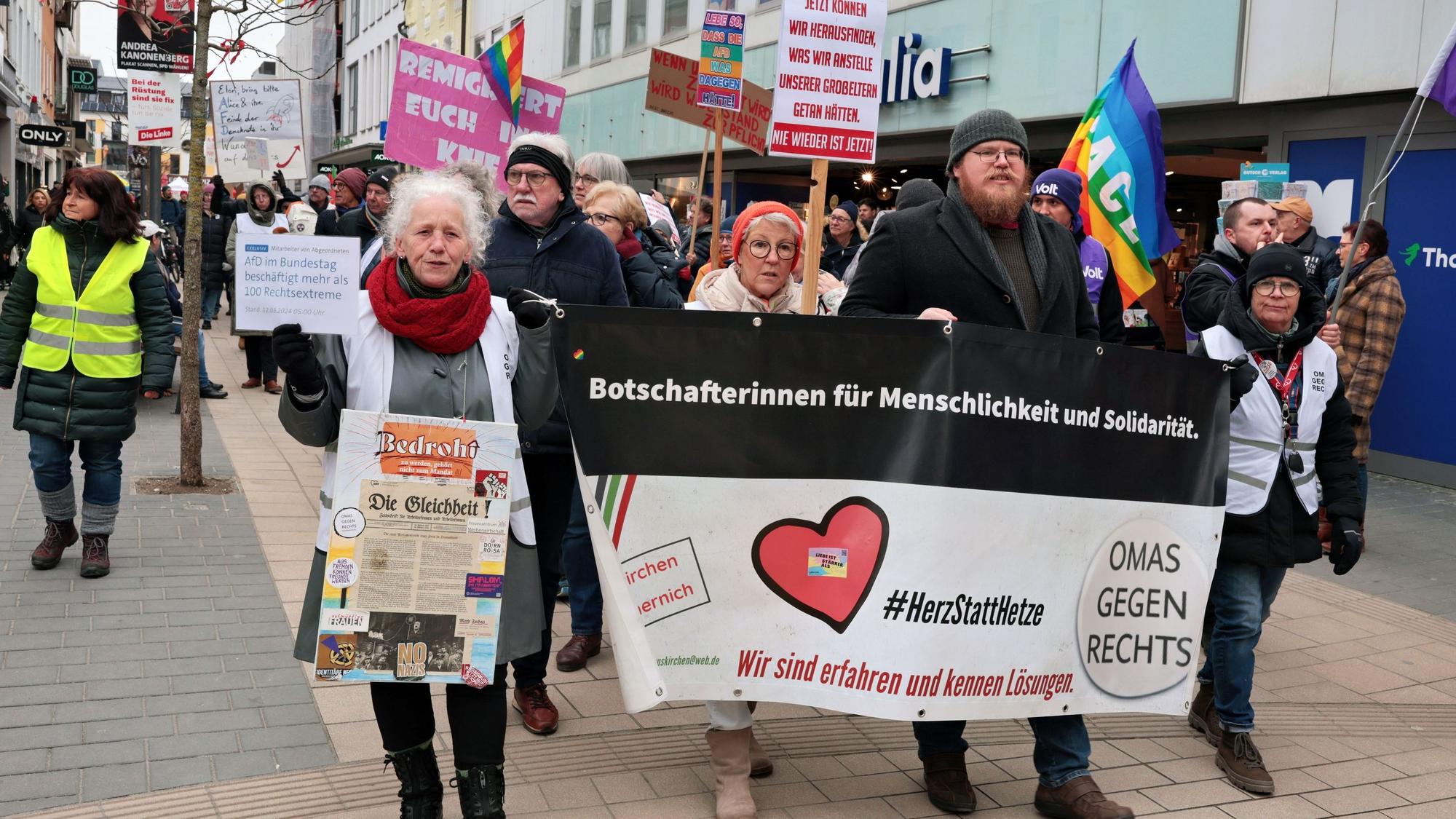 Rund 550 Teilnehmer demonstrierten in Euskirchen für Freiheit und Demokratie. Einige Teilnehmer halten Fahnen hoch oder gehen hinter einem Transparent der Omas gegen Rechts.