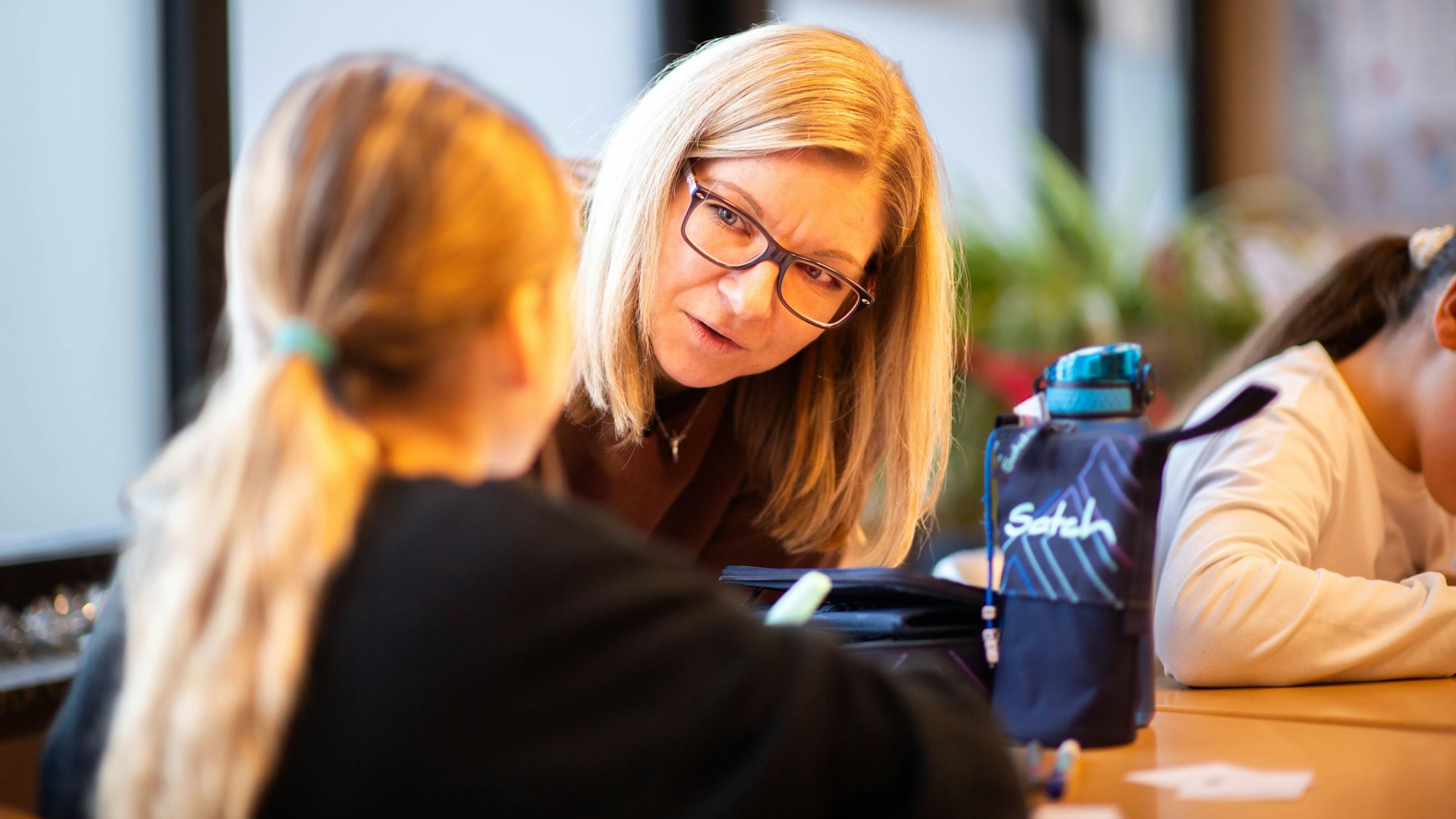 Das Bild zeigt die Lehrerin im Gespräch mit einer Schülerin.