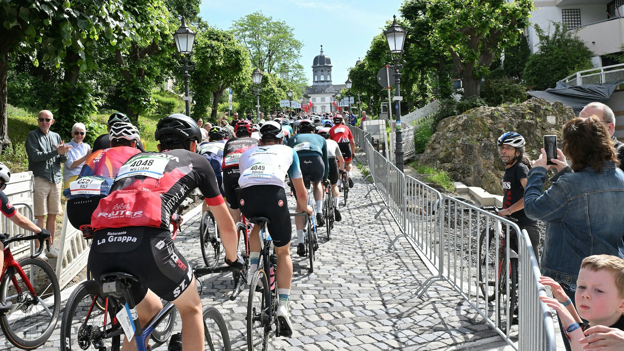 Radrennfahrer fahren den Schlossberg hinauf.