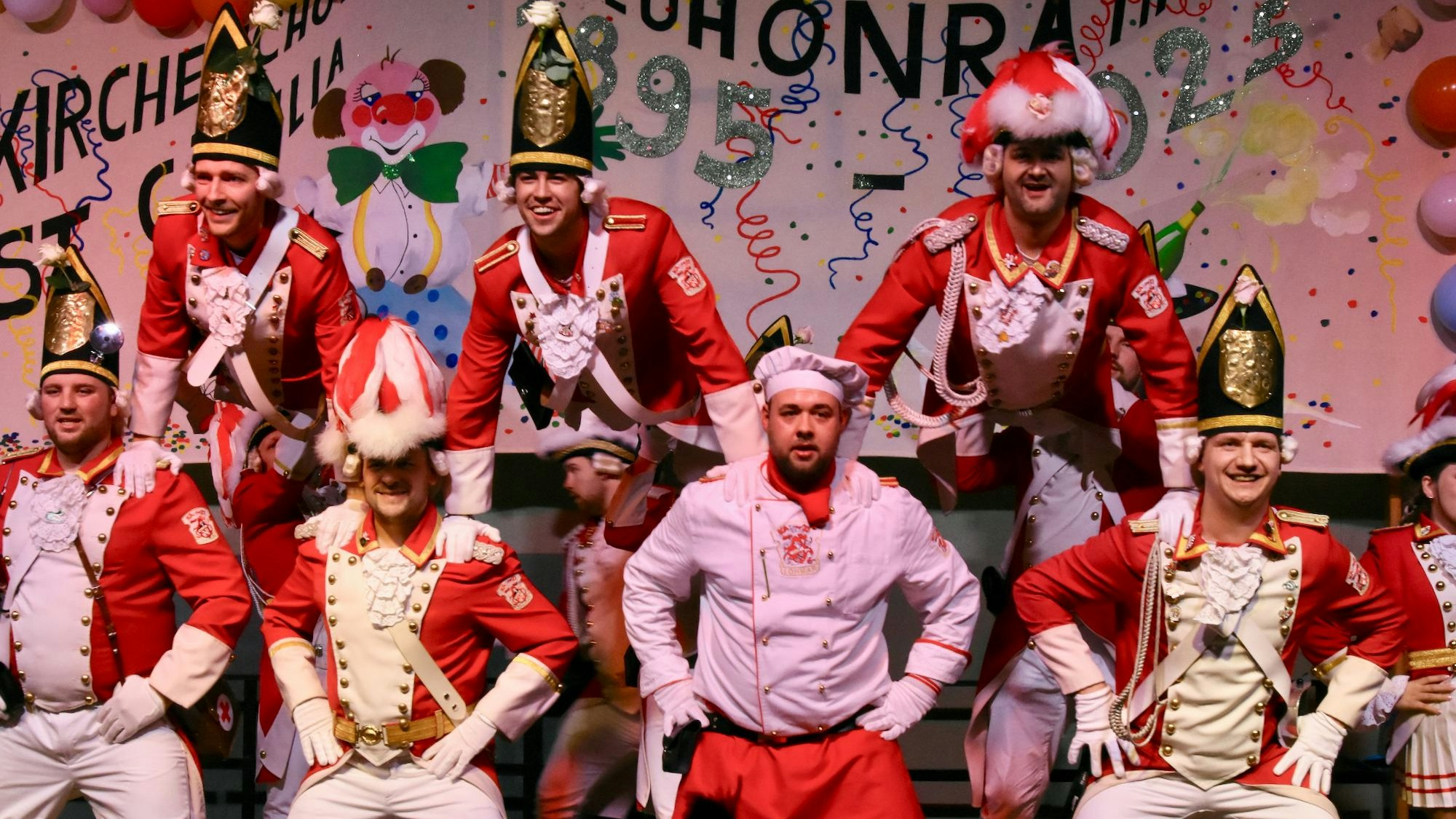 Ein Gardetanzcorps in rot-weißen Uniformen hat eine Pyramide gebildet.