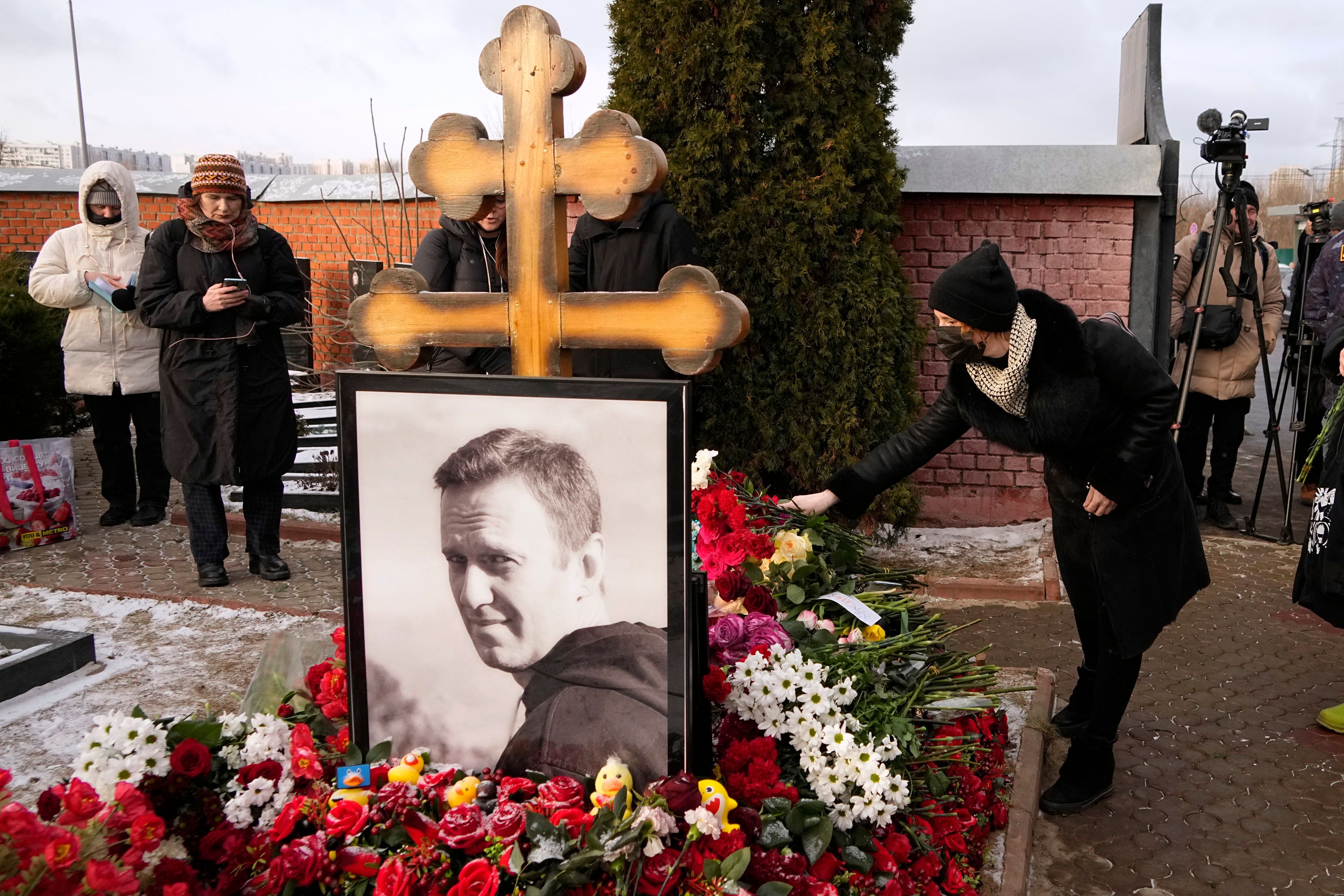dpatopbilder - 16.02.2025, Russland, Moskau: Eine Frau legt am ersten Jahrestag des Todes des russischen Oppositionsführers Alexej Nawalny auf dem Borisowskoje-Friedhof in Moskau Blumen nieder.