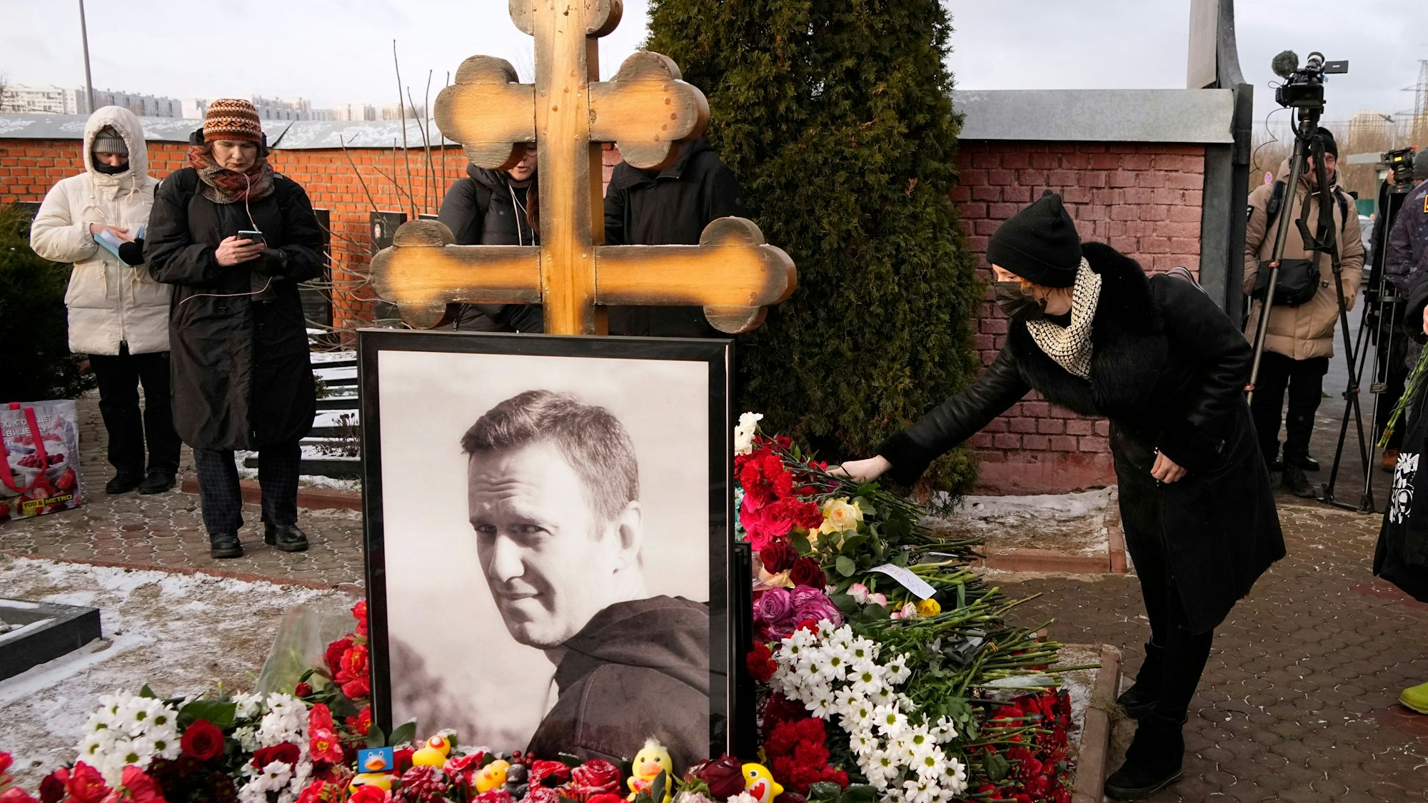 dpatopbilder - 16.02.2025, Russland, Moskau: Eine Frau legt am ersten Jahrestag des Todes des russischen Oppositionsführers Alexej Nawalny auf dem Borisowskoje-Friedhof in Moskau Blumen nieder.