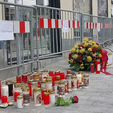 16.02.2025, Österreich, Villach: Blumen und Kerzen am Tatort des Messerangriffs. Ein Mann hat am Samstag, 15. Februar 2025, in Villach auf mehrere Passanten eingestochen und einen von ihnen getötet. Foto: Peter Lindner/APA/dpa +++ dpa-Bildfunk +++