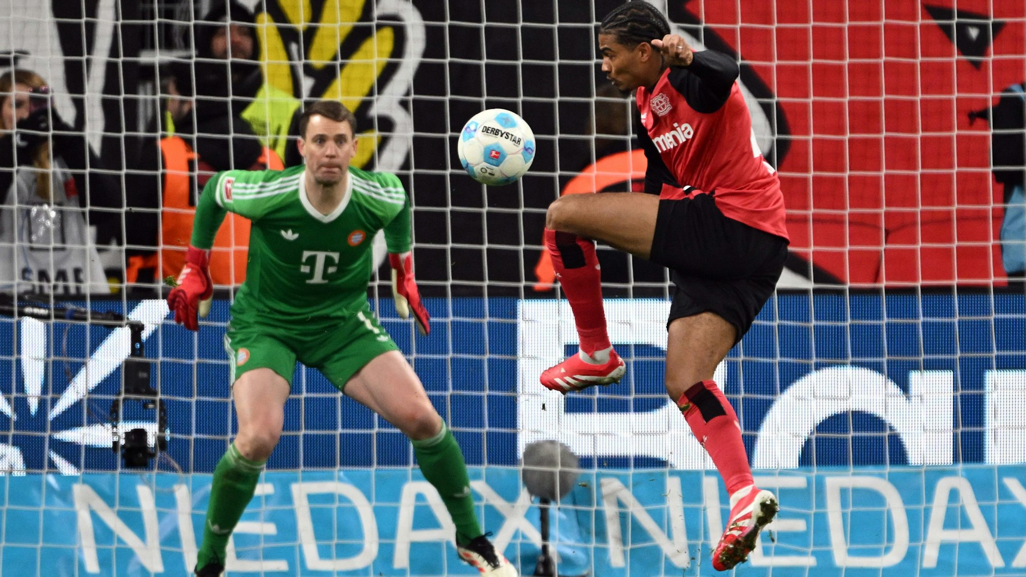 15.02.2025, Nordrhein-Westfalen, Leverkusen: Fußball: Bundesliga, Bayer Leverkusen - Bayern München, 22. Spieltag, BayArena, Leverkusens Amine Adli (r) gegen Bayerns Torwart Manuel Neuer. Foto: Federico Gambarini/dpa - WICHTIGER HINWEIS: Gemäß den Vorgaben der DFL Deutsche Fußball Liga bzw. des DFB Deutscher Fußball-Bund ist es untersagt, in dem Stadion und/oder vom Spiel angefertigte Fotoaufnahmen in Form von Sequenzbildern und/oder videoähnlichen Fotostrecken zu verwerten bzw. verwerten zu lassen. +++ dpa-Bildfunk +++