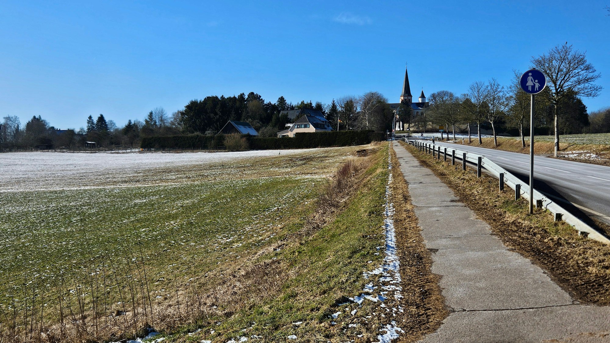 Blick auf die Felder und Wiesen mit Steinfeld im Hintergrund.