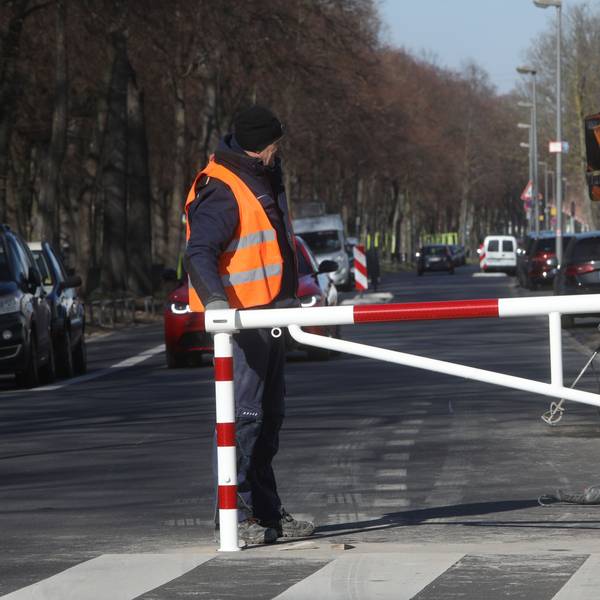 Arbeiter bauen eine Schranke auf der Alfred-Schütte-Allee auf
