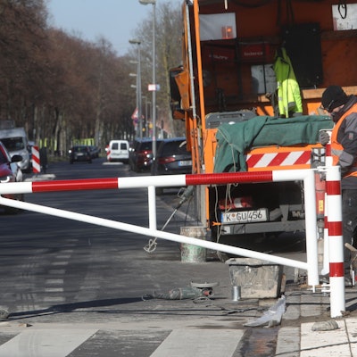 Arbeiter bauen eine Schranke auf der Alfred-Schütte-Allee auf