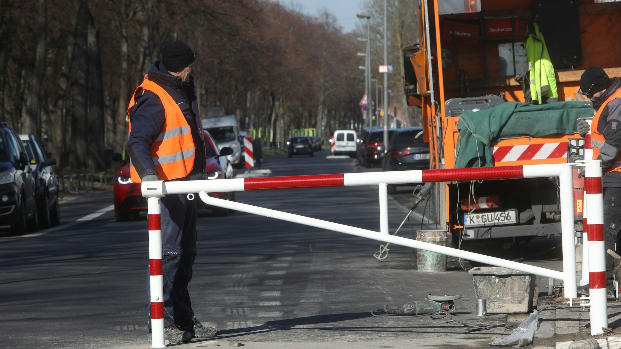 Arbeiter bauen eine Schranke auf der Alfred-Schütte-Allee auf